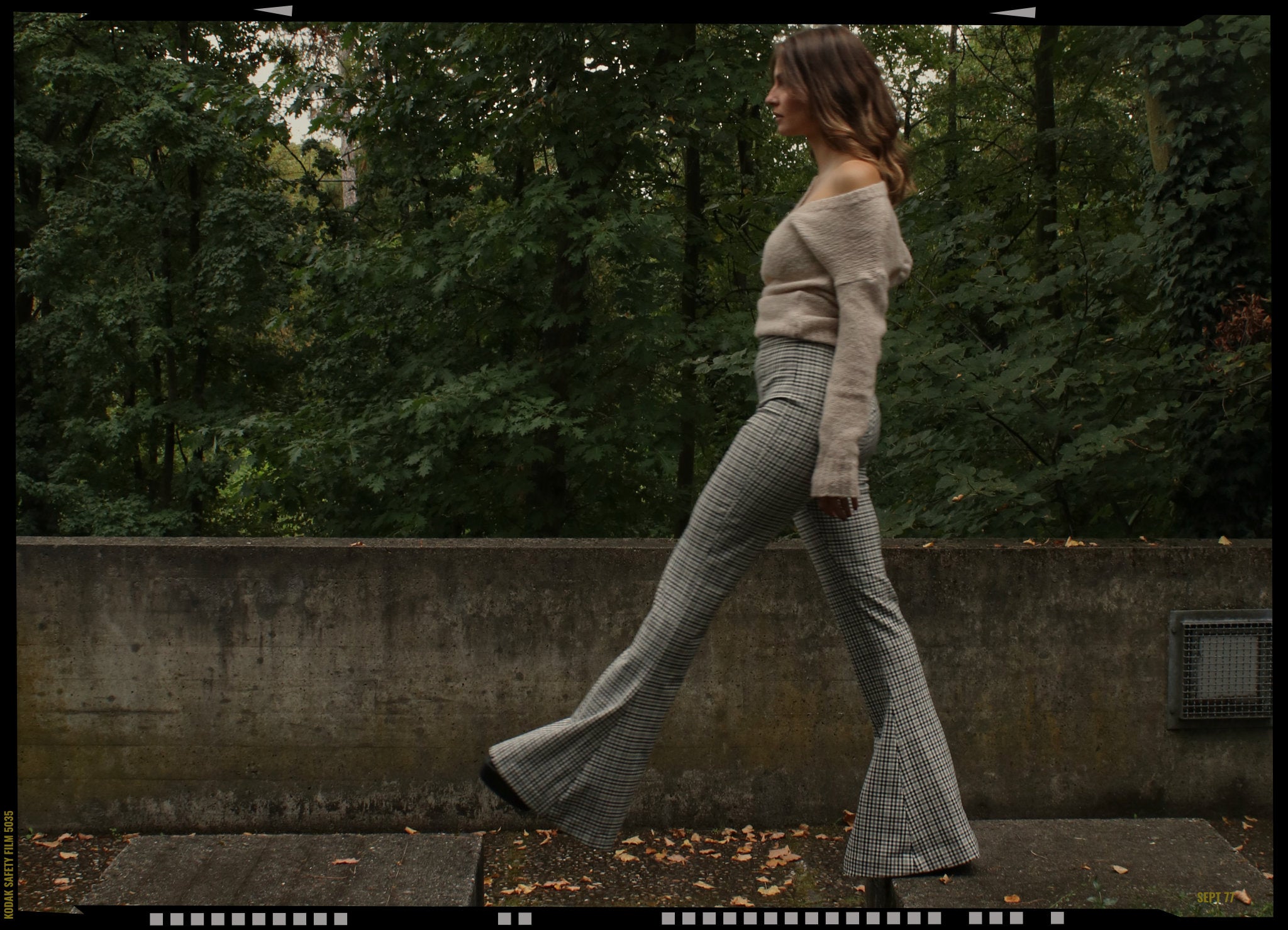 Secondhand Markenmode: Figurbetonte Hose mit Glencheck-Muster von Bec + Bridge kombiniert mit Off-Shoulder Strickpullover von Anine Bing – nachhaltiger Designer-Look in modernem Streetstyle Setting