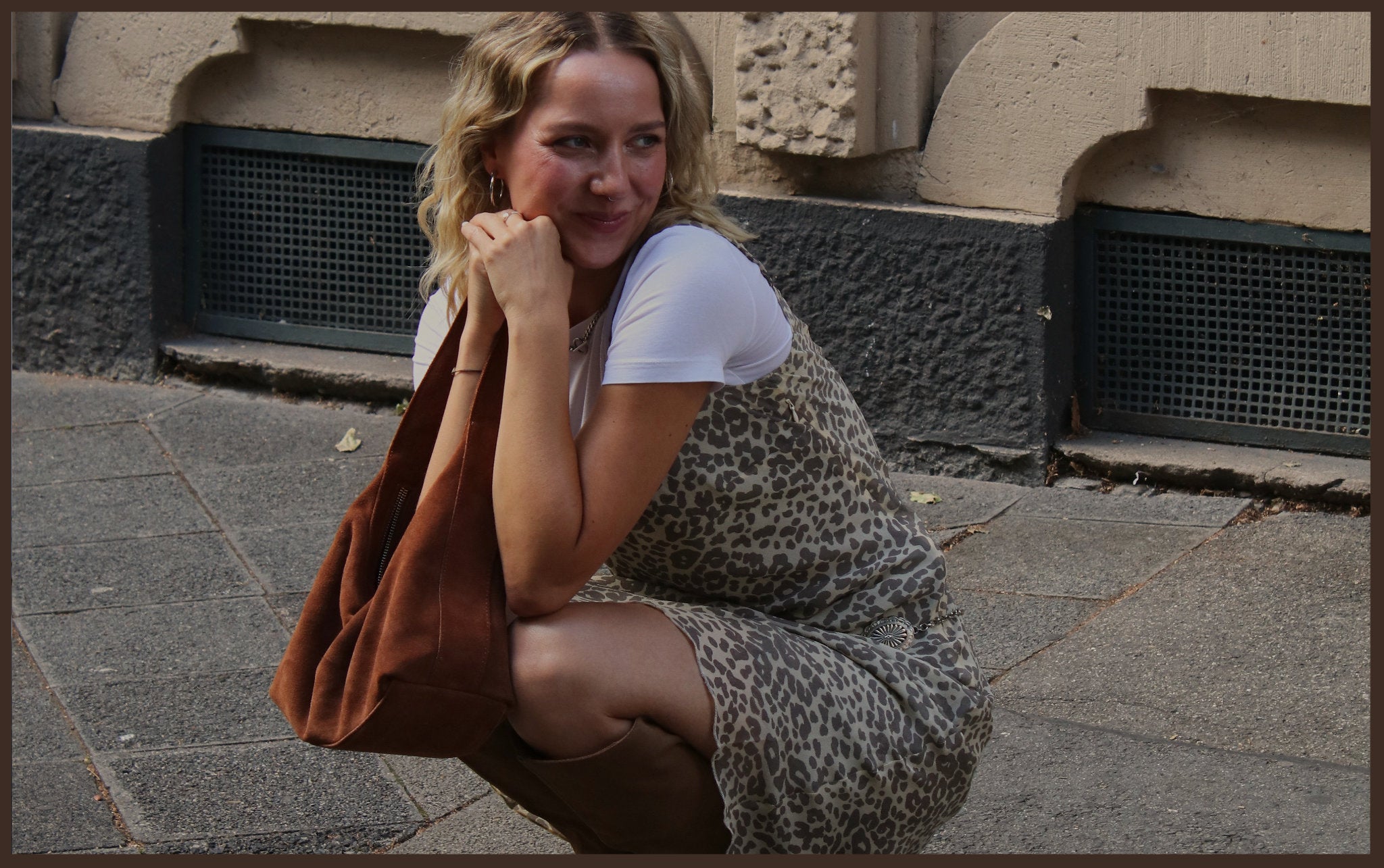 Model in Vintage Midi-Kleid aus Seide mit Leo-Print mit Tasche und Stiefeln aus Wildleder