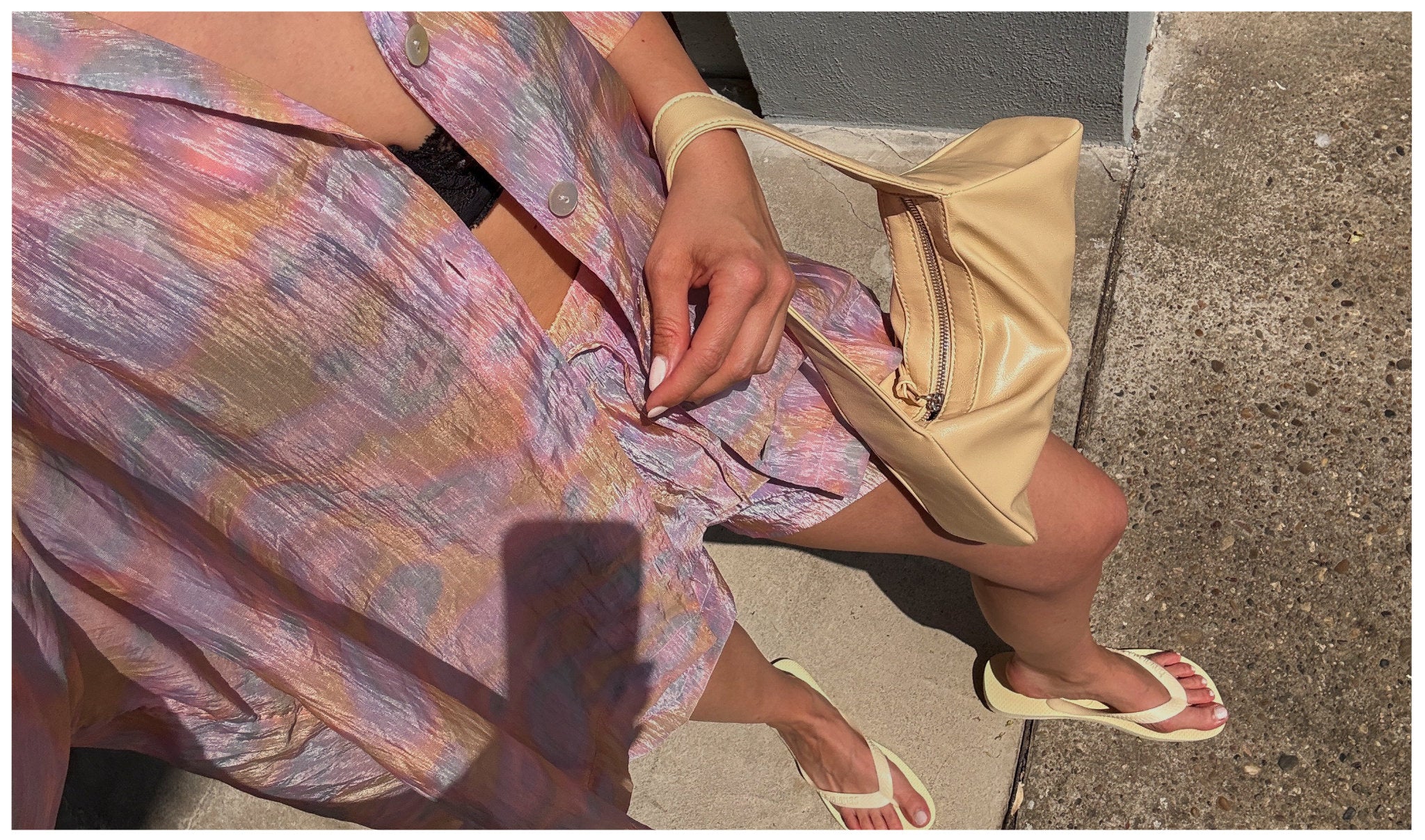 Nahaufnahme eines sommerlichen Secondhand-Outfits mit pastellfarbenem Zweiteiler in Rosa, Flieder und Gelb von & Other Stories. Dazu cremefarbene Tasche und Flip-Flops – leichter Vintage-Sommerlook in der Sonne